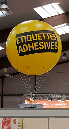Un ballon en hélium avec une impression publicitaire jaune et un logo. 